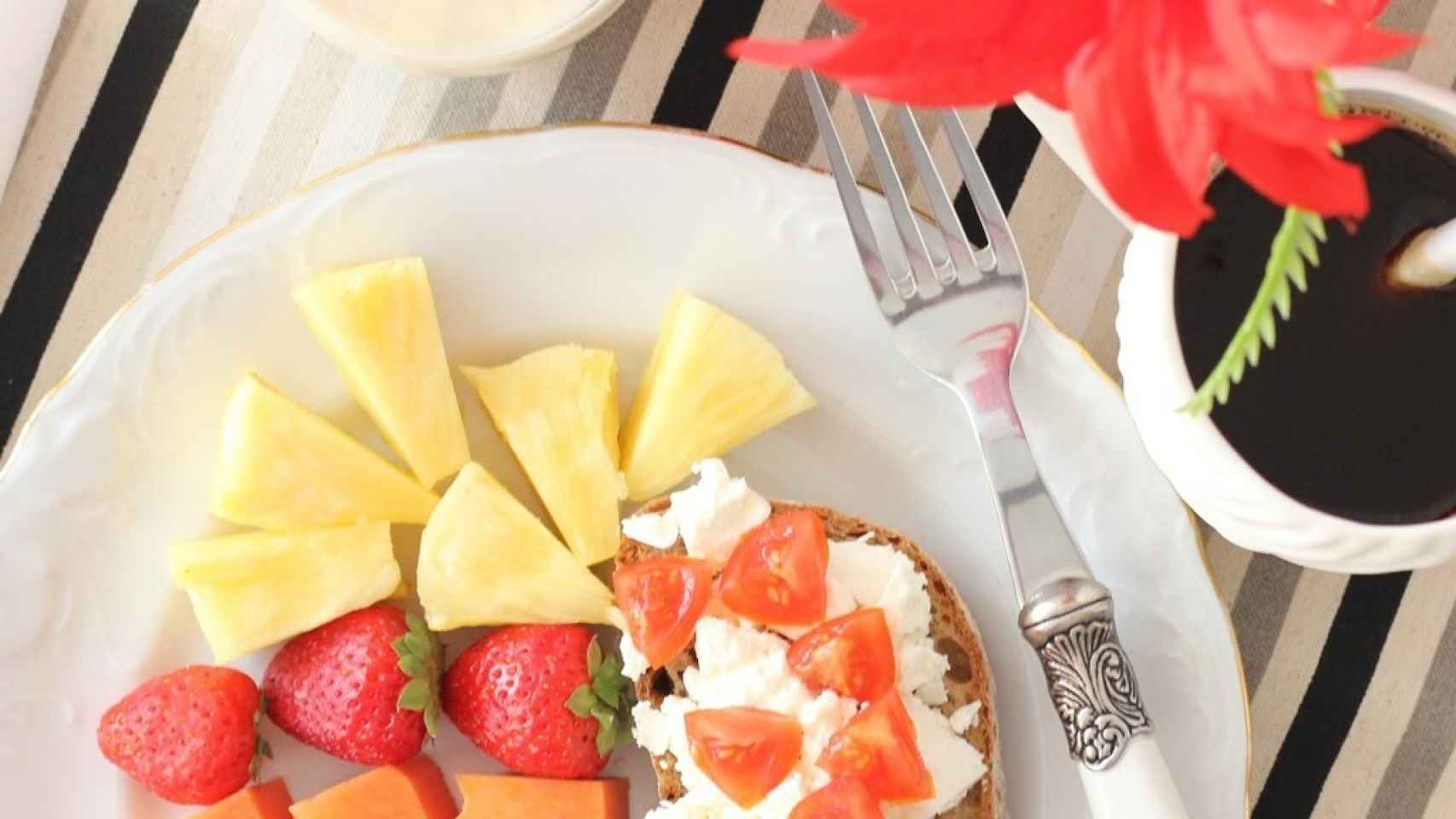 Pan tostado, queso cottage, tomate y fruta