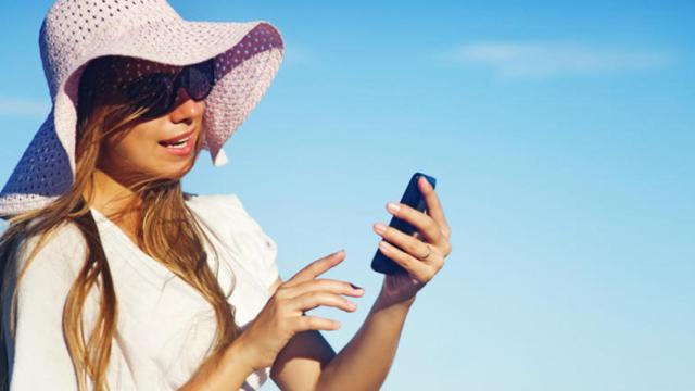 Persona utilizando el móvil en verano