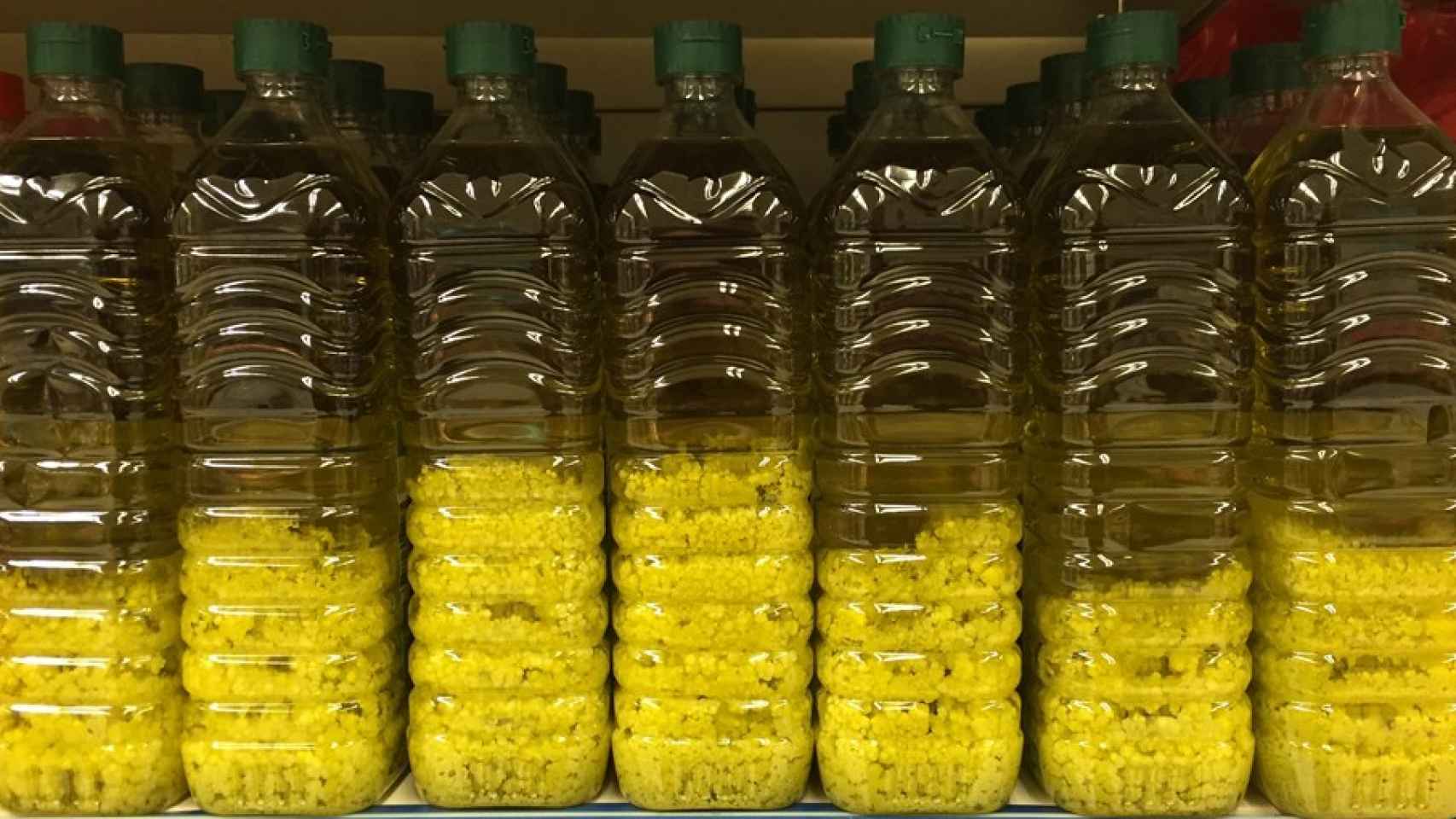 Botellas de aceite de oliva con grumos blancos en un supermercado