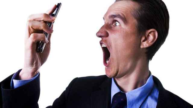 businessman looking and screaming at phone