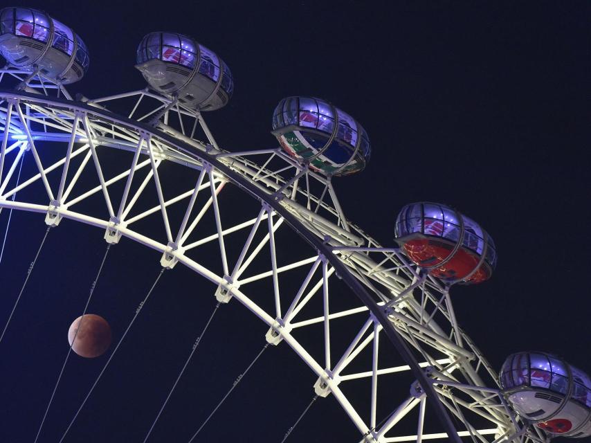 La luna a través de la noria London Eye.