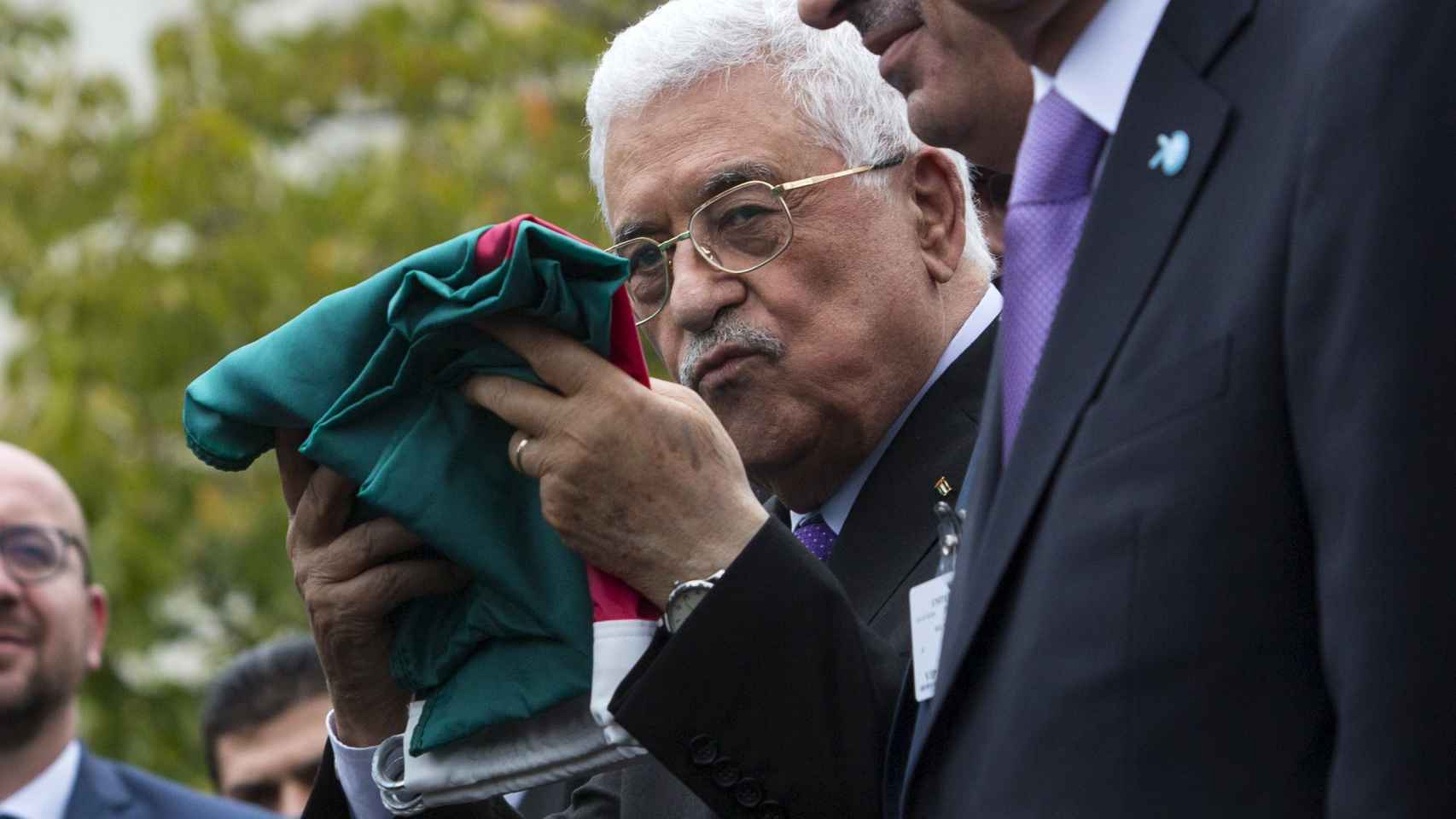 El presidente de la Autoridad Nacional Palestina, Mahmud Abbas, sostiene una bandera palestina en el cuartel general de la ONU.