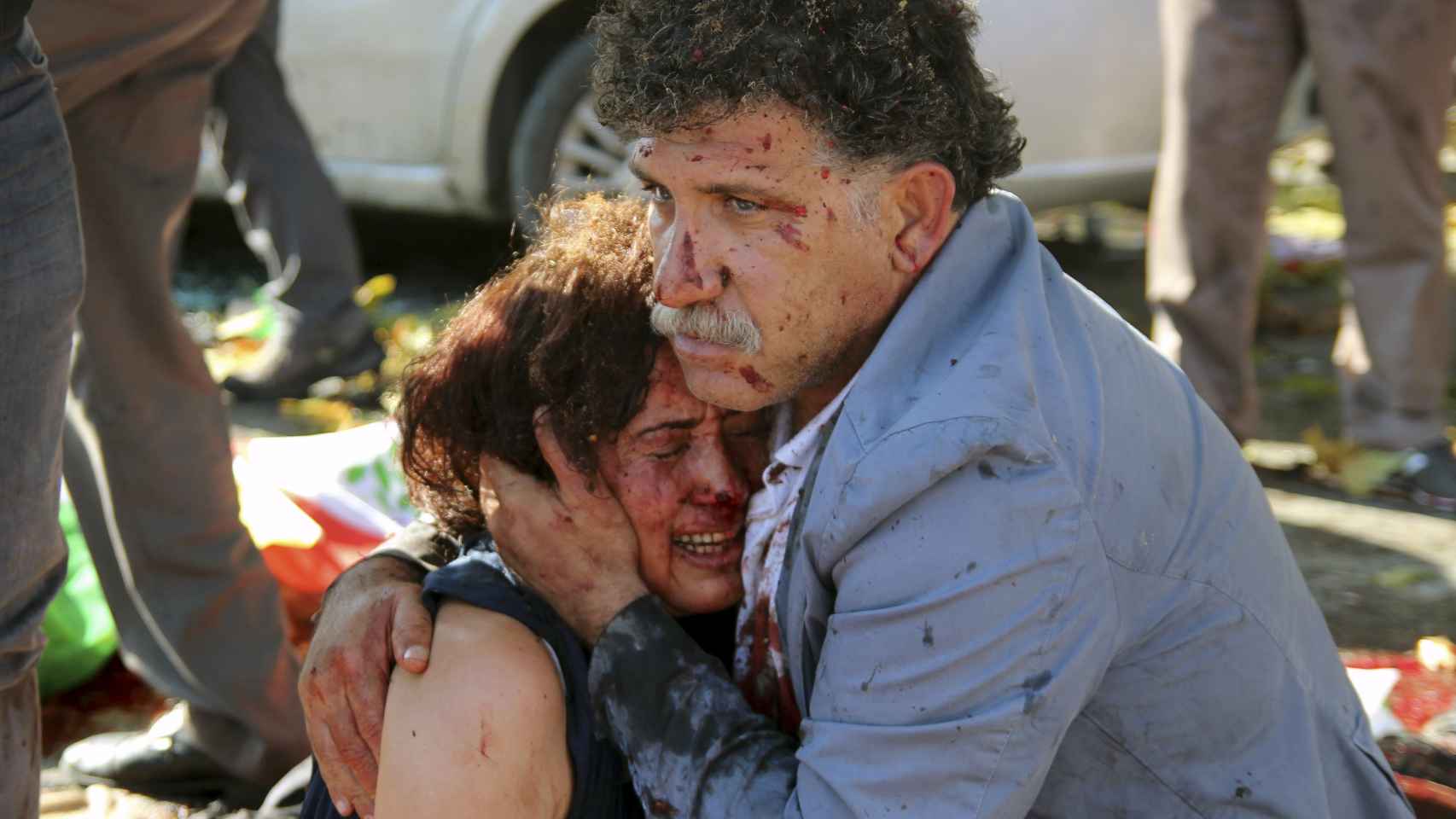 Un hombre abraza a una mujer herida tras la explosión.