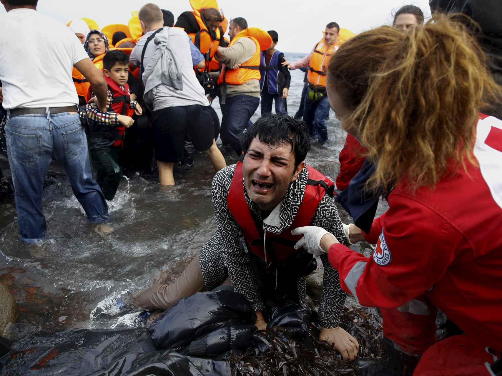 Un refugiado sirio llora al desembarcar de una balsa inundada.