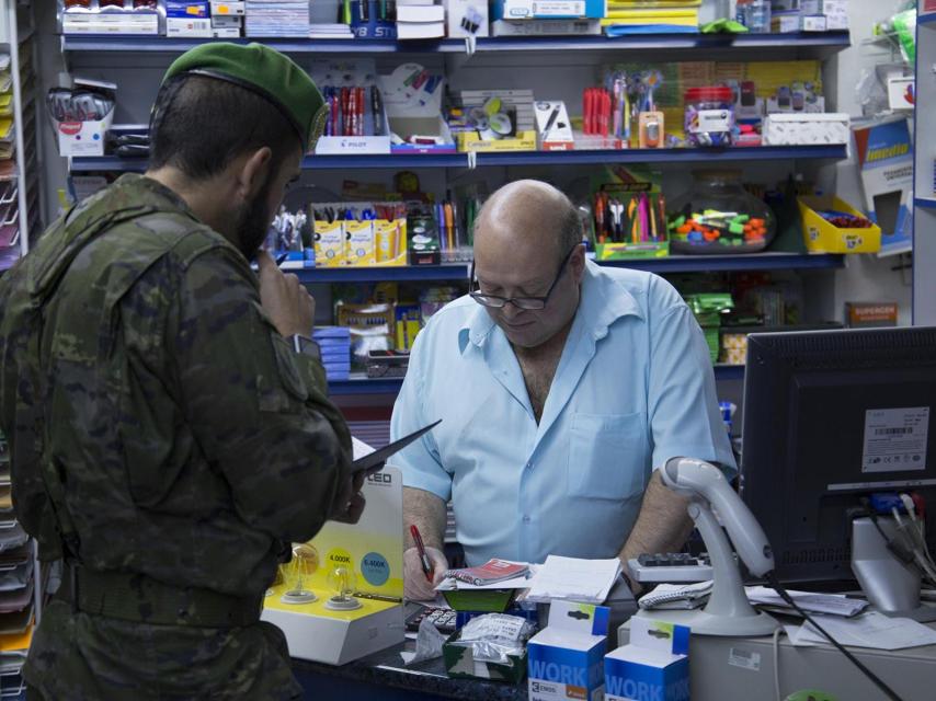 El capitán Ballesteros compra en un establecimiento de la localidad.