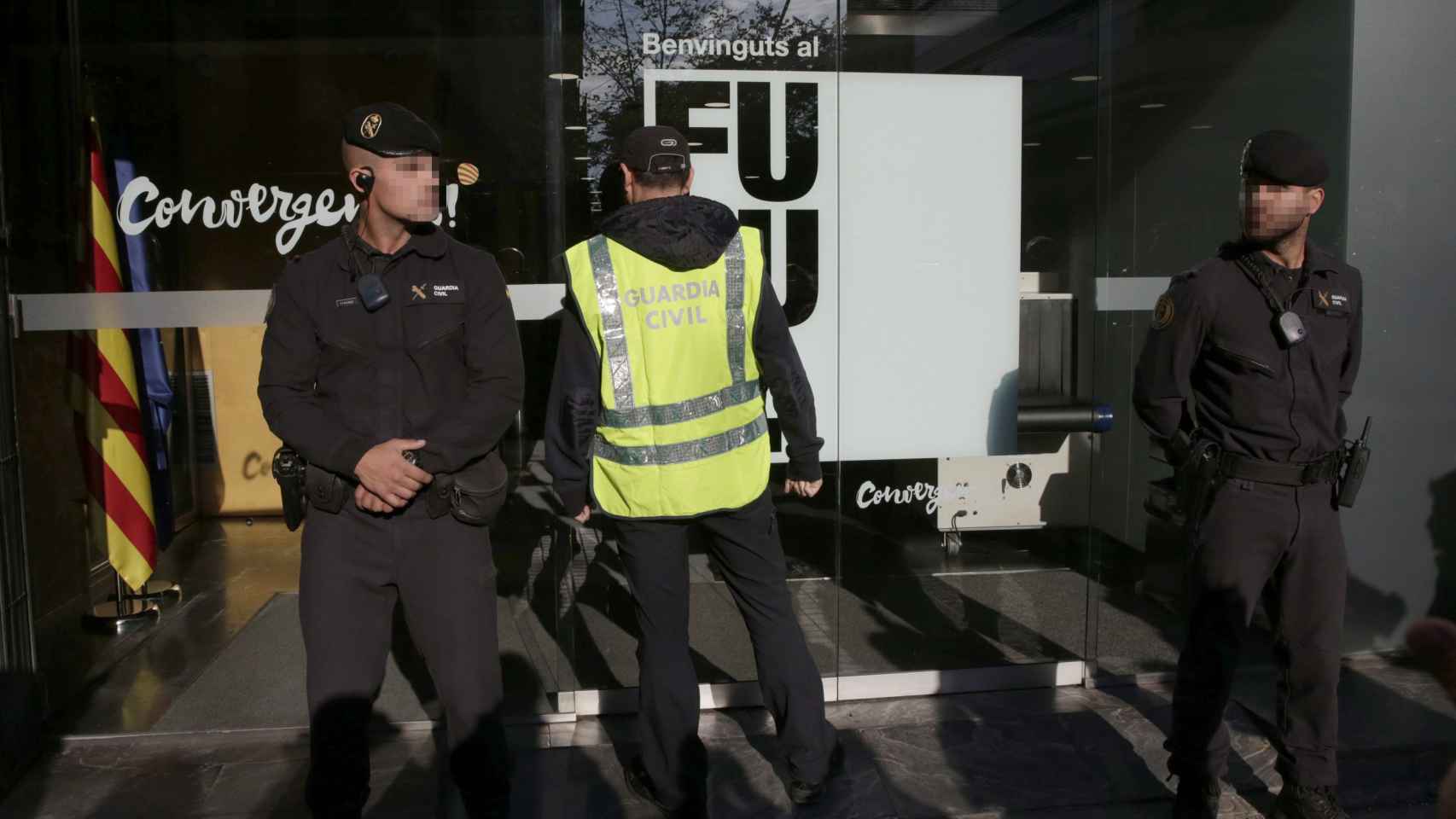 Agentes ante la fachada de la sede de CDC en Barcelona durante su registro este miércoles
