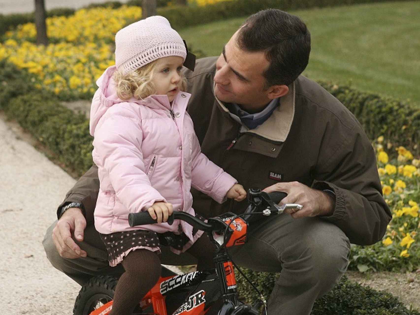 Leonor aprende a montar en bicicleta ayudada por su padre