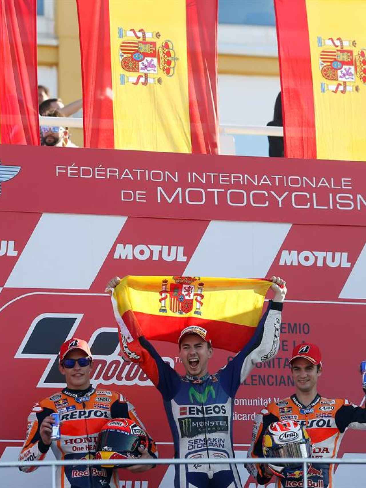 Lorenzo celebra en el podio rodeado de banderas españolas.