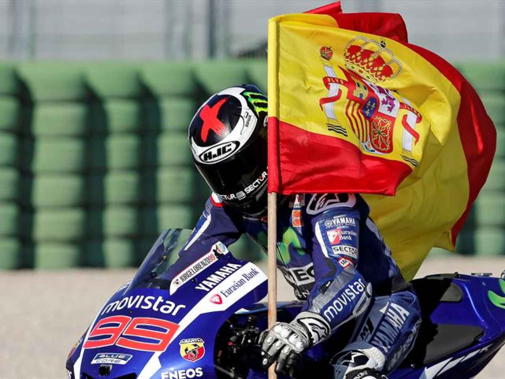 El piloto porta una bandera tras ganar la carrera.