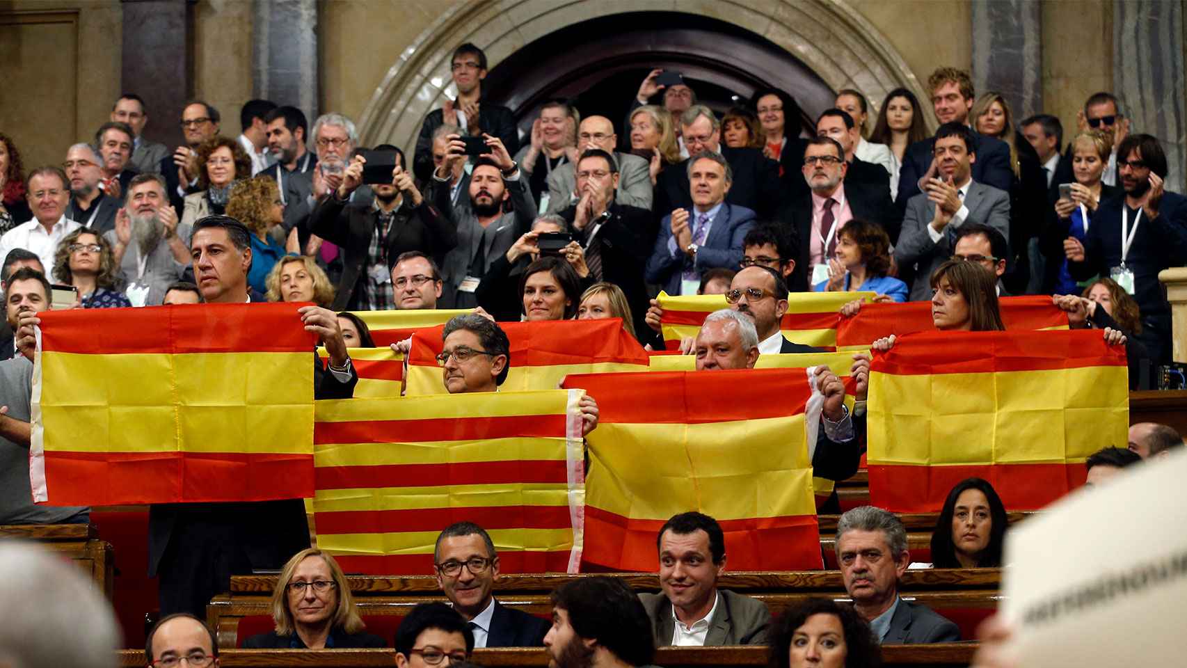 Los diputados del PP muestran banderas españolas y catalanas tras la votación.