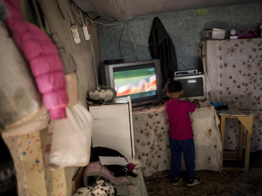Un niño intenta cambiar de canal en su casa.