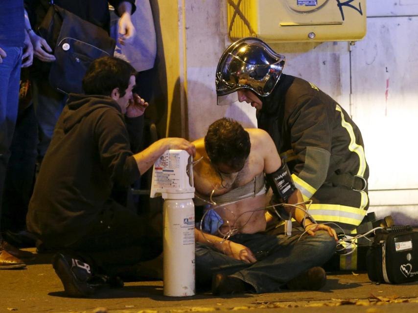 Los bomberos atienden a uno de los heridos. / Reuters