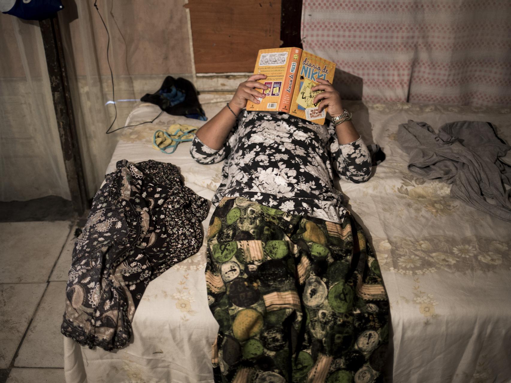 Valica, de 11 años, leyendo en su cama