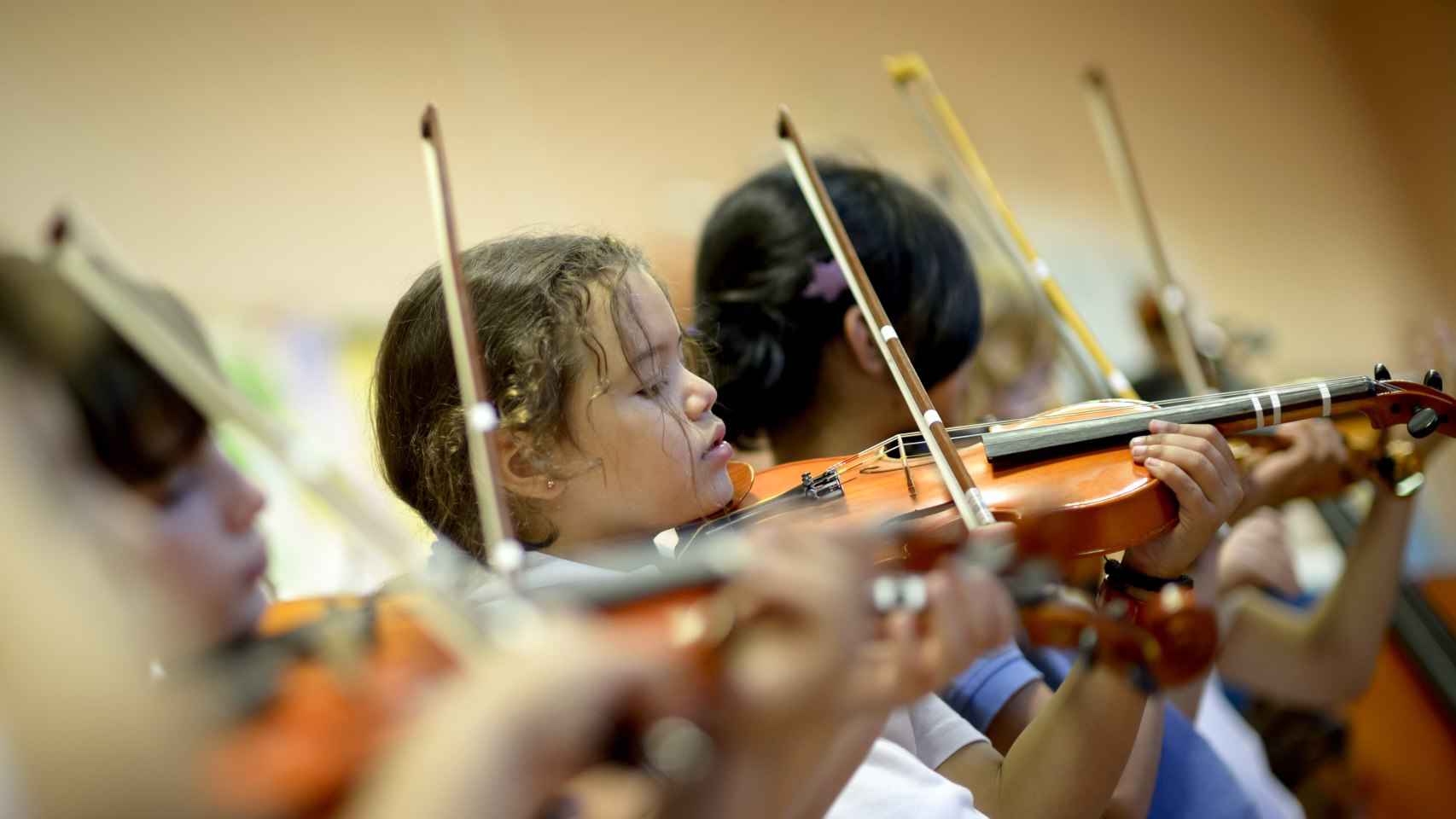 Niños tocando el violín.