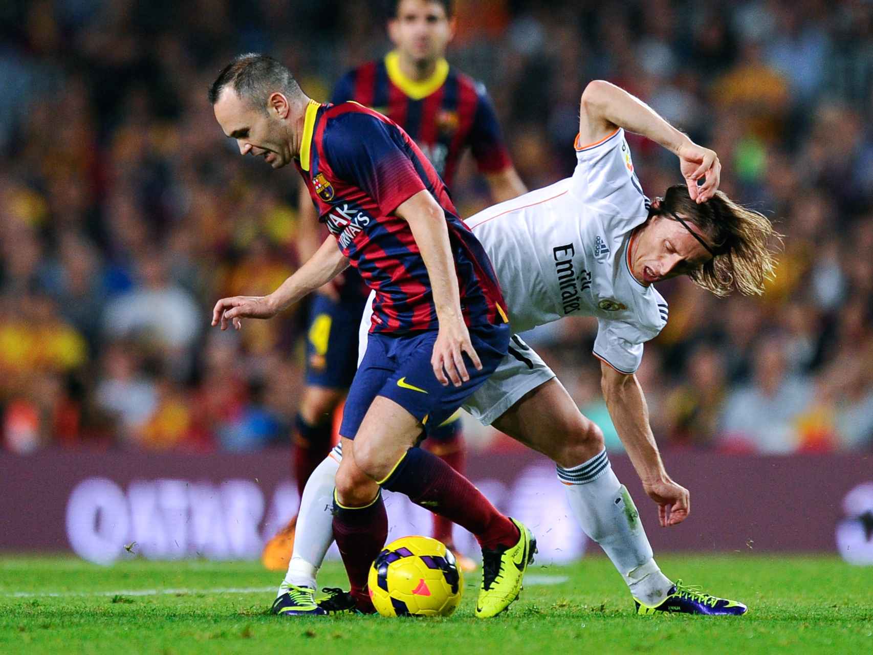 Andrés Iniesta y Luka Modric disputan un balón.