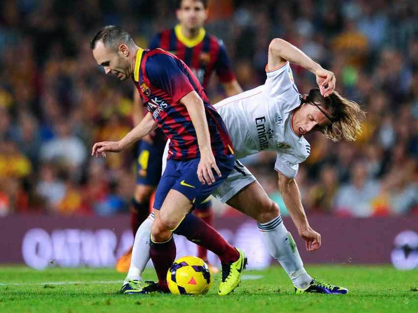 Andrés Iniesta y Luka Modric disputan un balón.