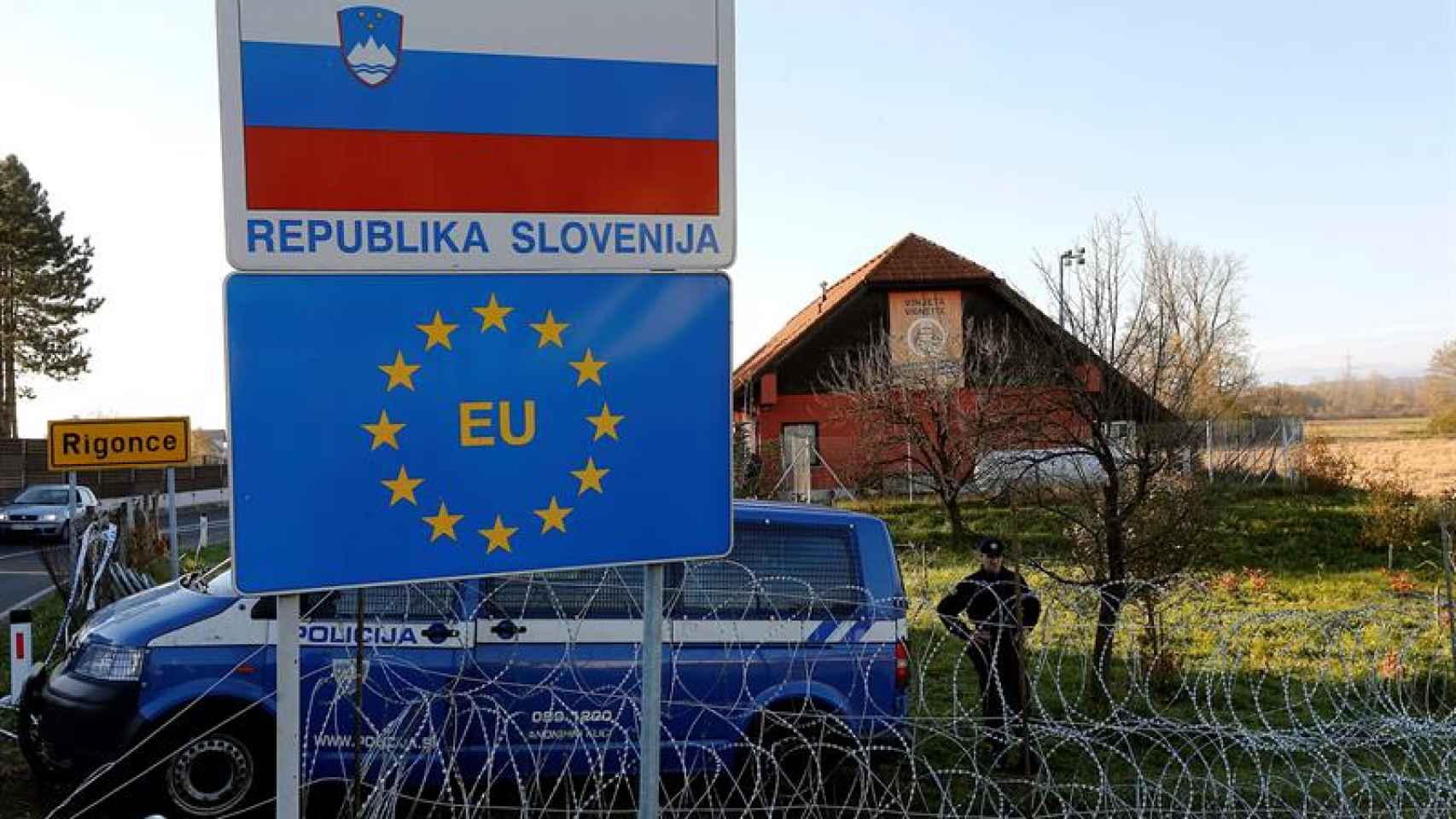 Policías eslovenos montan guardia junto a la valla levantada en su frontera con Croacia.