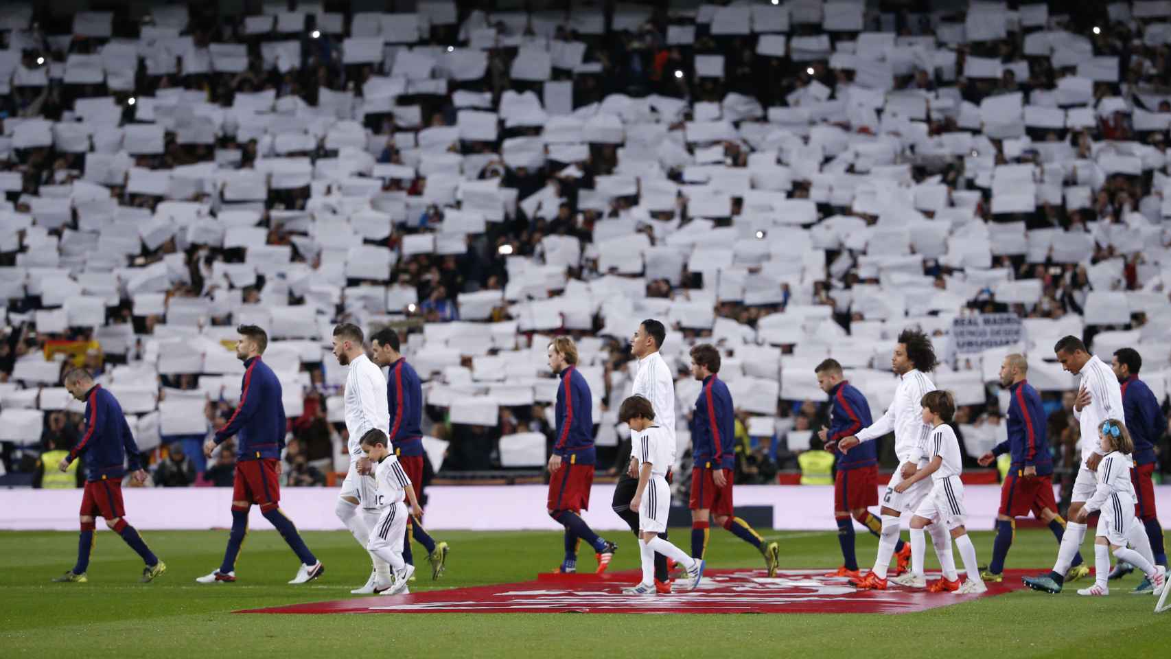 Los jugadores de Madrid y Barça en el momento de saltar al césped del Bernabéu.