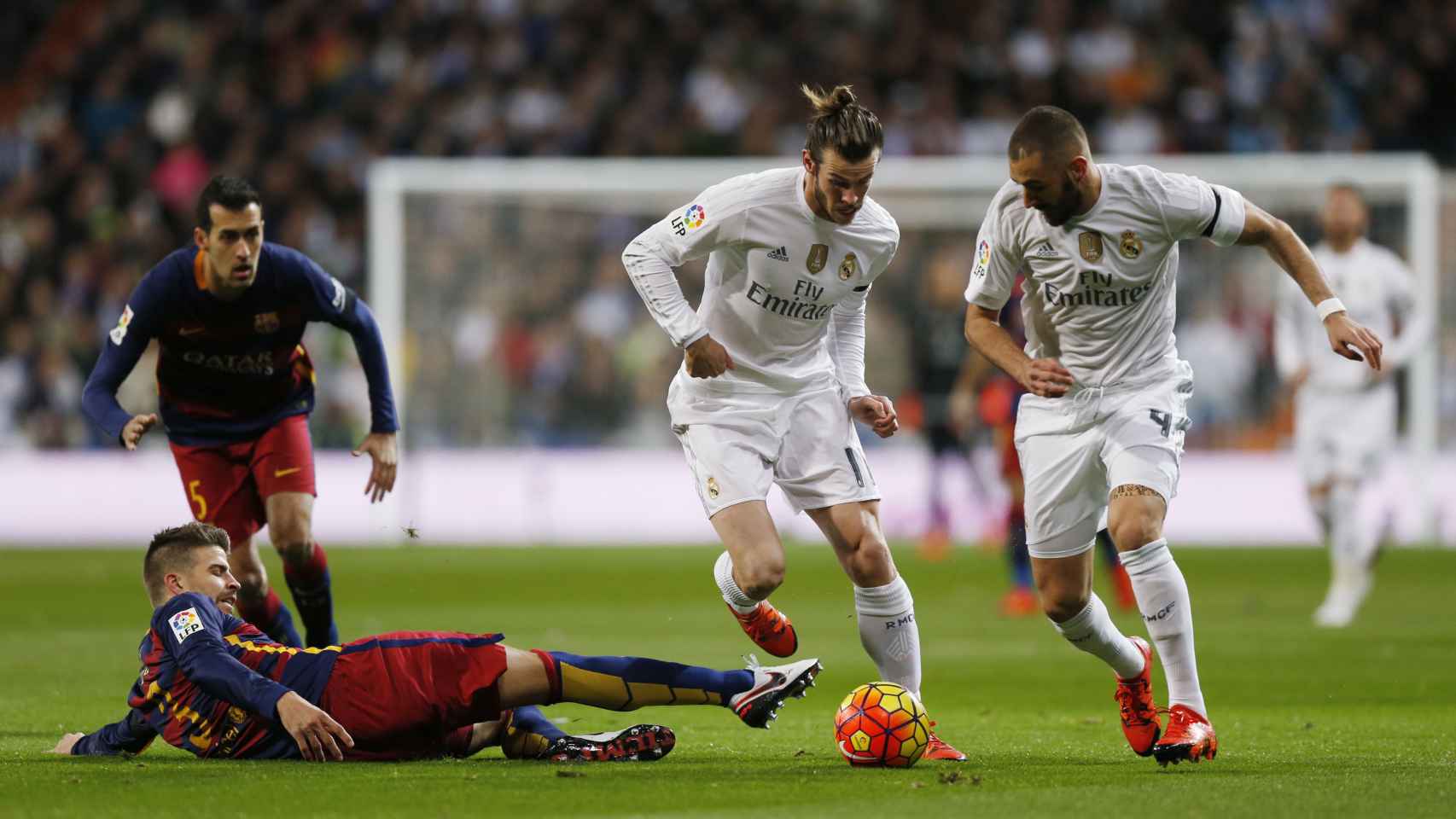 Bale conduce el balón junto a Benzema con la oposición de Piqué.