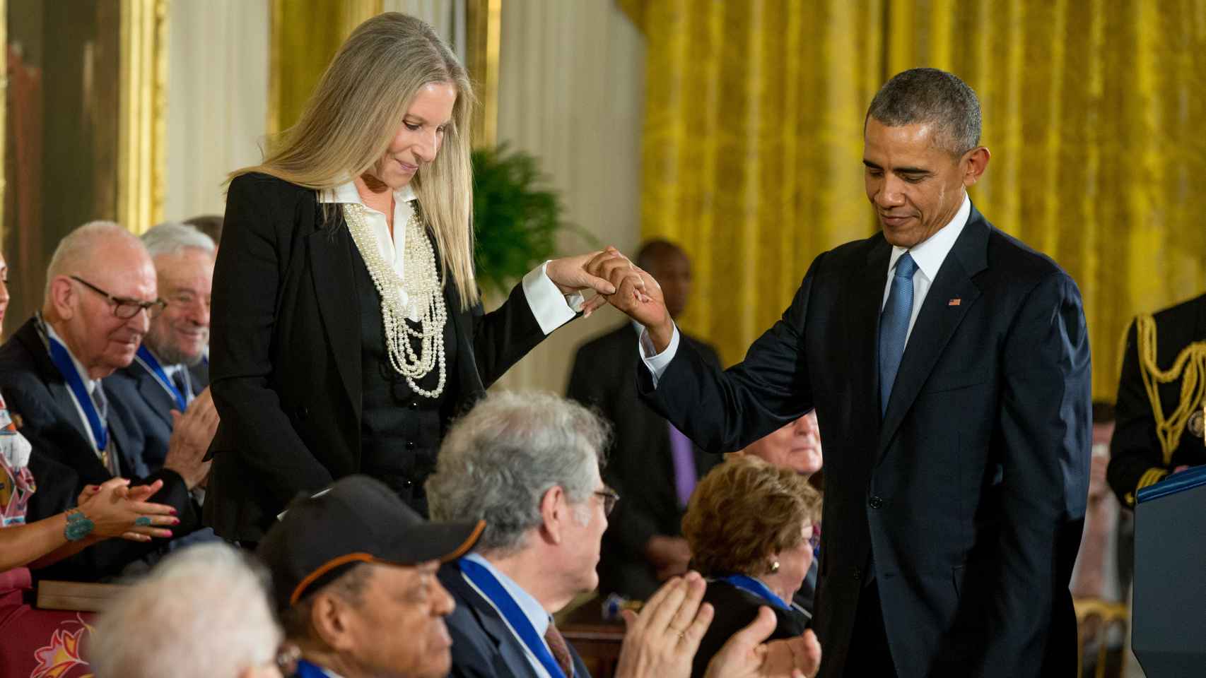 Obama ayuda a bajar las escaleras a Barbara Streisand