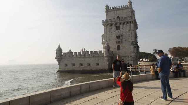 Unos viandantes se fotografían ante la emblemática Torre de Belén en Lisboa.