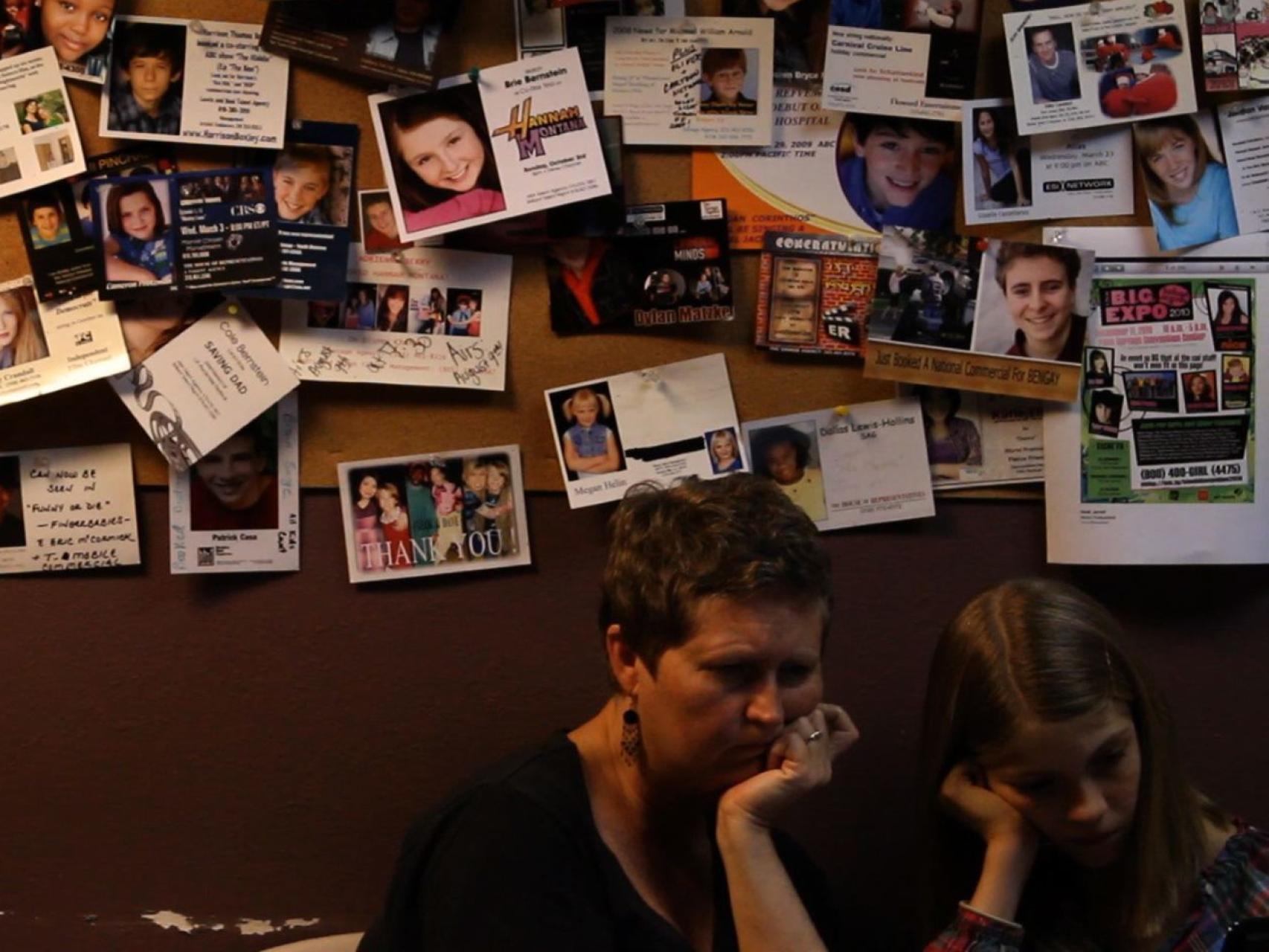 Madre e hija,en la sala de espera de una agencia.