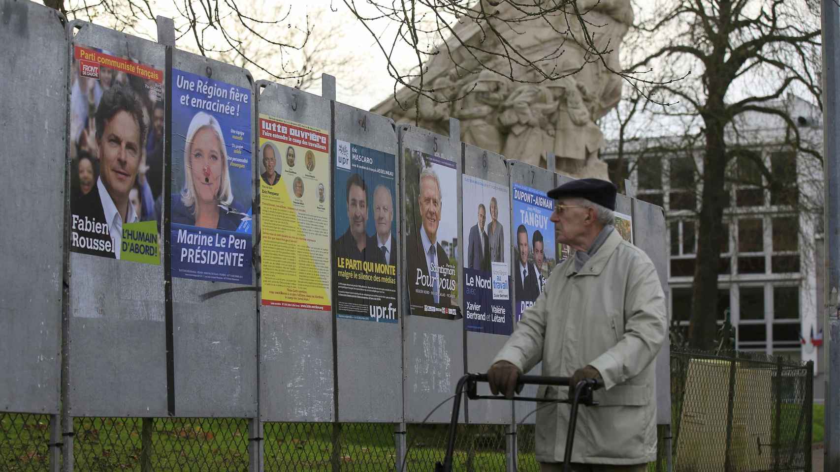 Un ciudadano francés pasea ante los carteles electorales.