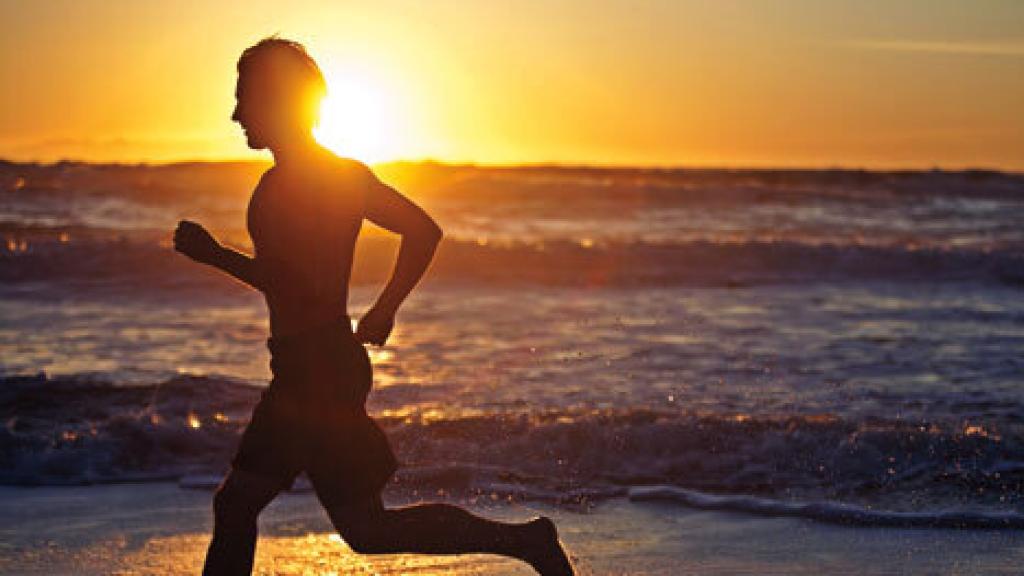 Un joven corriendo por la playa.