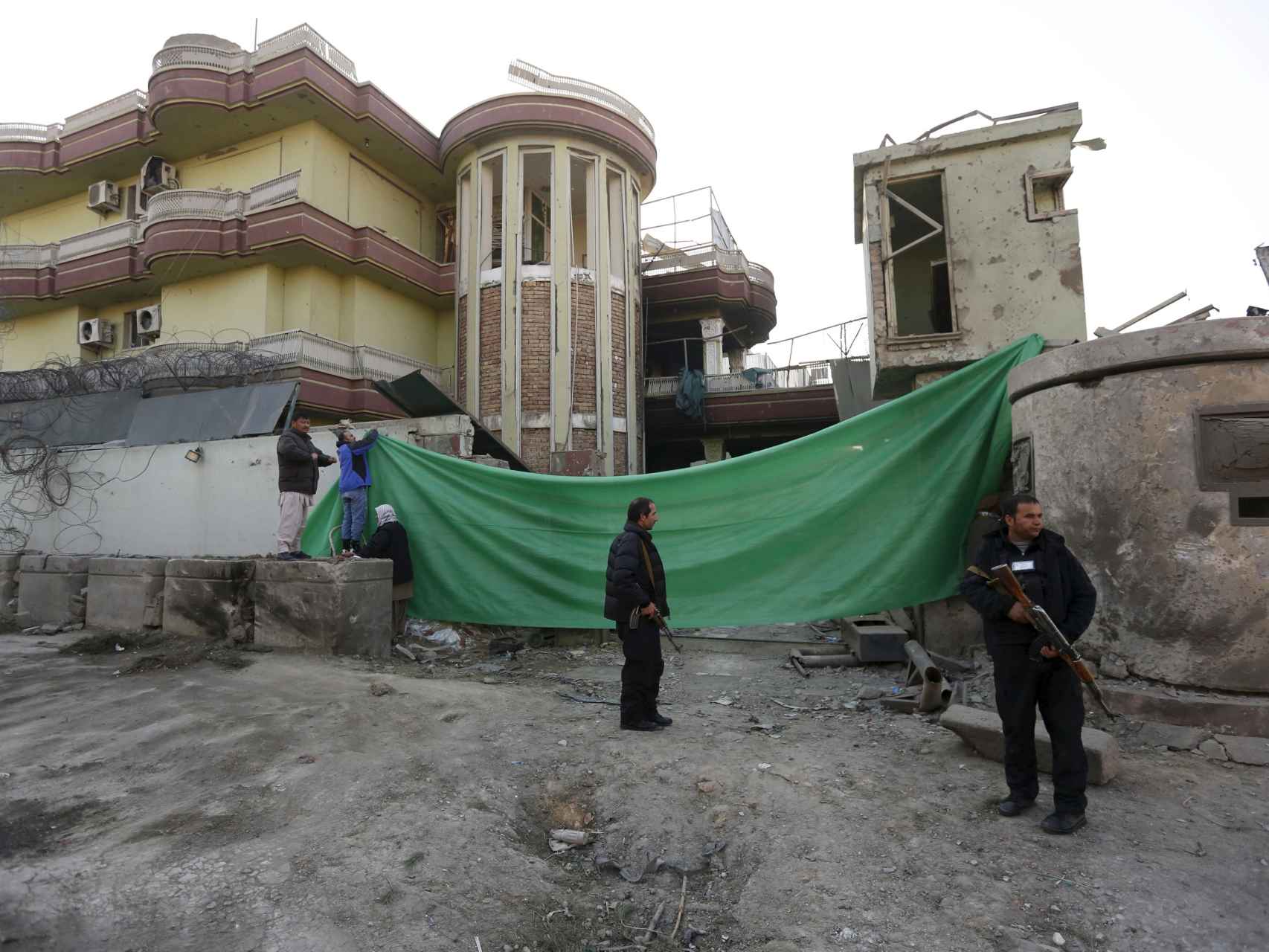 Las autoridades afganas hacen guardia frente al edificio atacado.