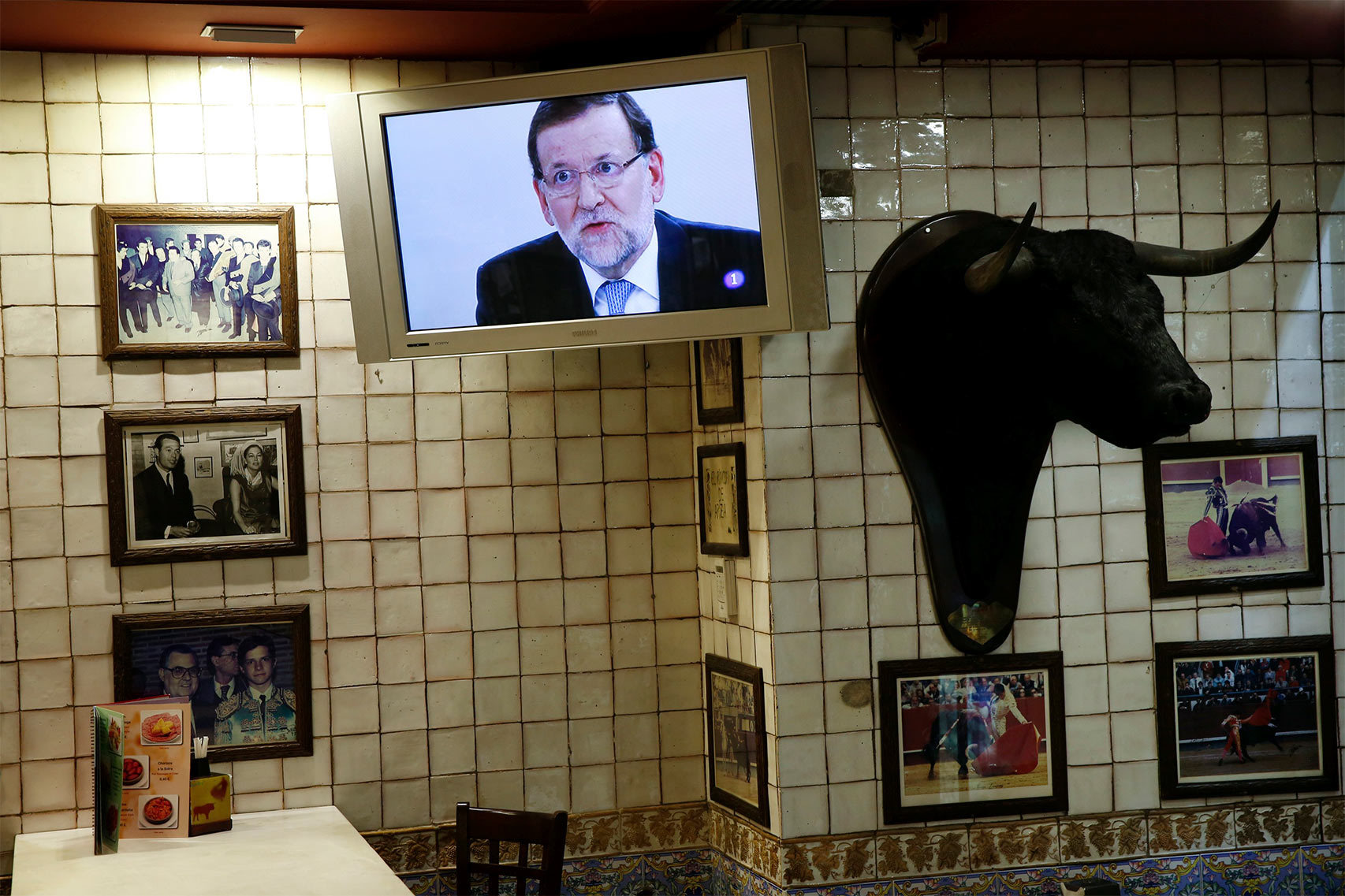Una pantalla de plasma proyecta la imagen de Rajoy en un bar durante el debate.