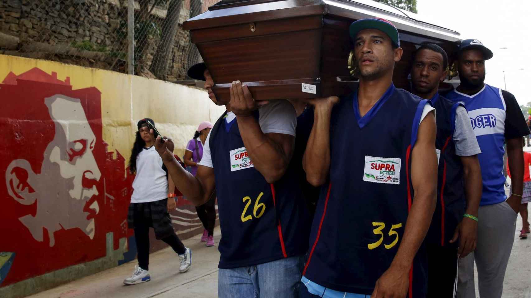Compañeros de un jugador de baloncesto víctima de un crimen en Caracas portan su féretro.