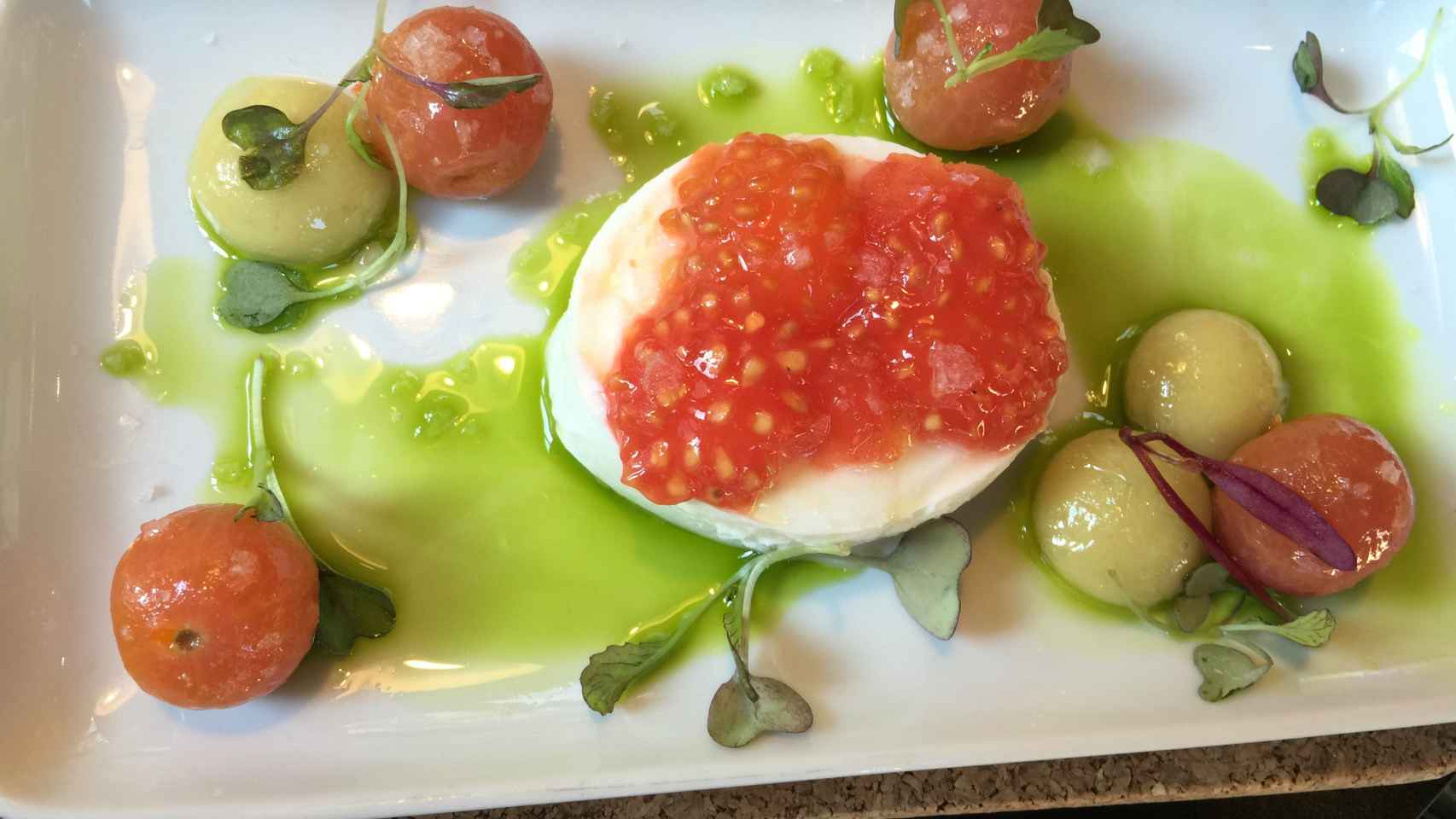 Ensalada de tomate con esferas de mozzarella y Oliva.