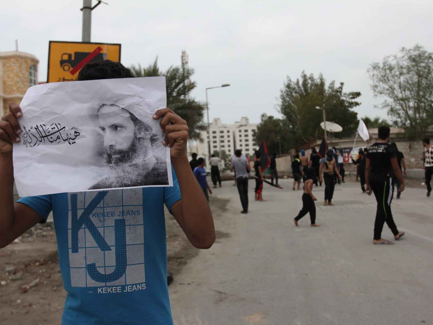 Un manifestante de Bahrein con una imagen de Nimr al Nimr.