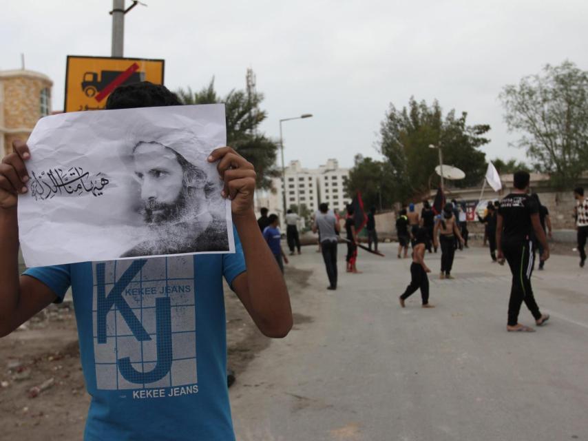 Un manifestante de Bahrein con una imagen de Nimr al Nimr.