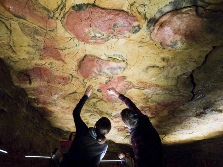 Dos visitantes en la reproducción de la cueva de Altamira.