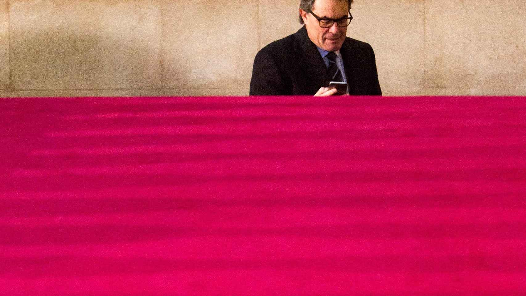 Artur Mas consulta su móvil a su llegada al Parlament.