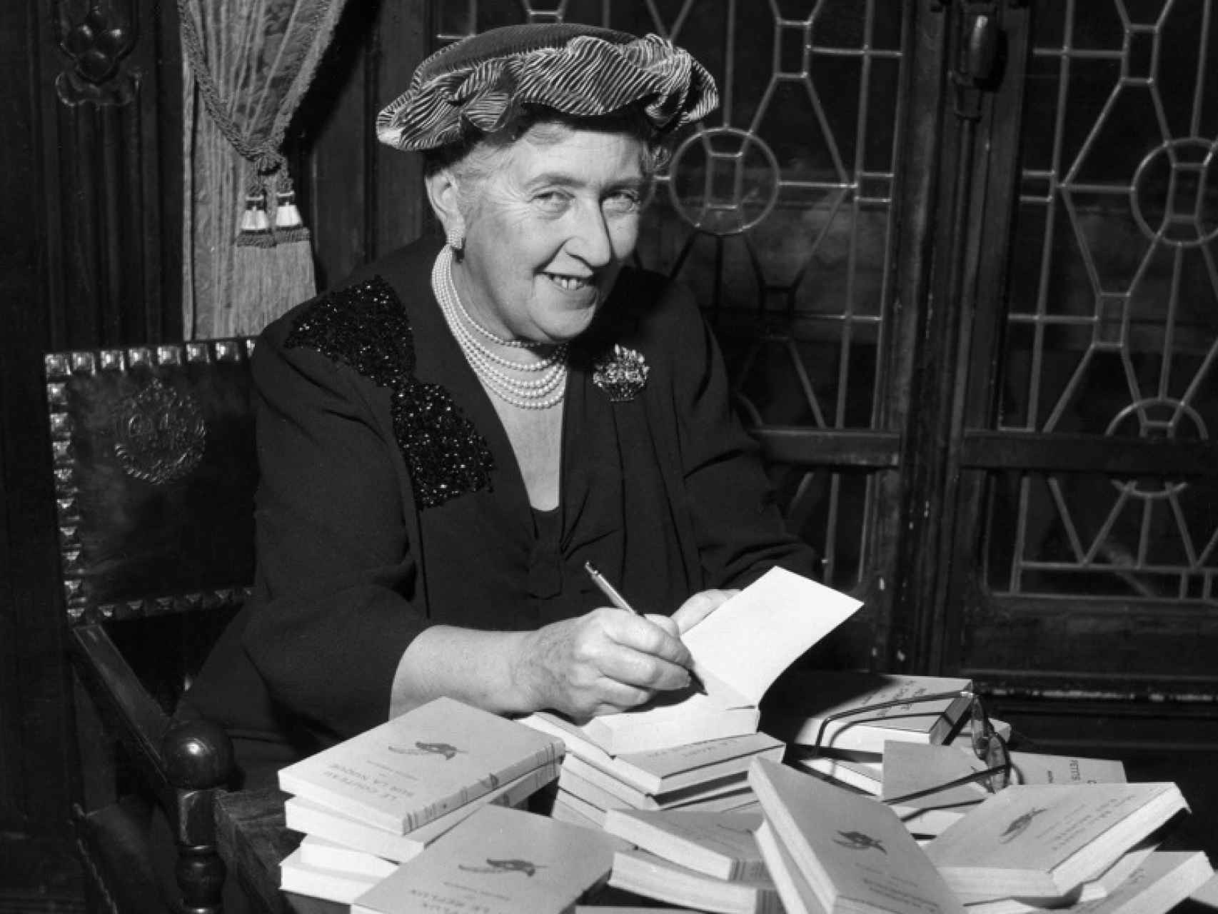 Agatha Christie (1890-1976) firmando ediciones francesas de sus obras.