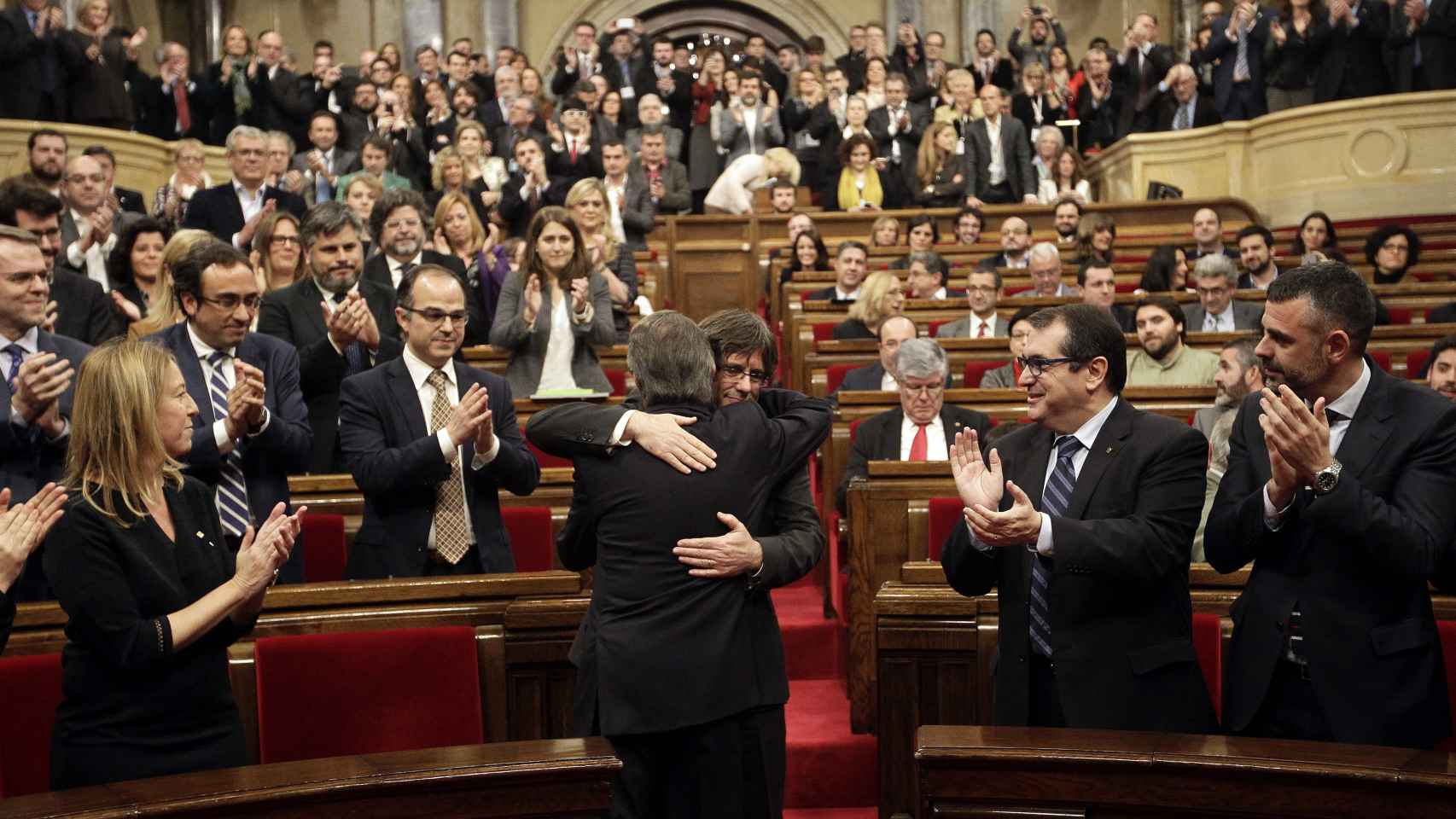 El Parlament aplaude el abrazo entre Artur Mas y Carles Puigdemont.