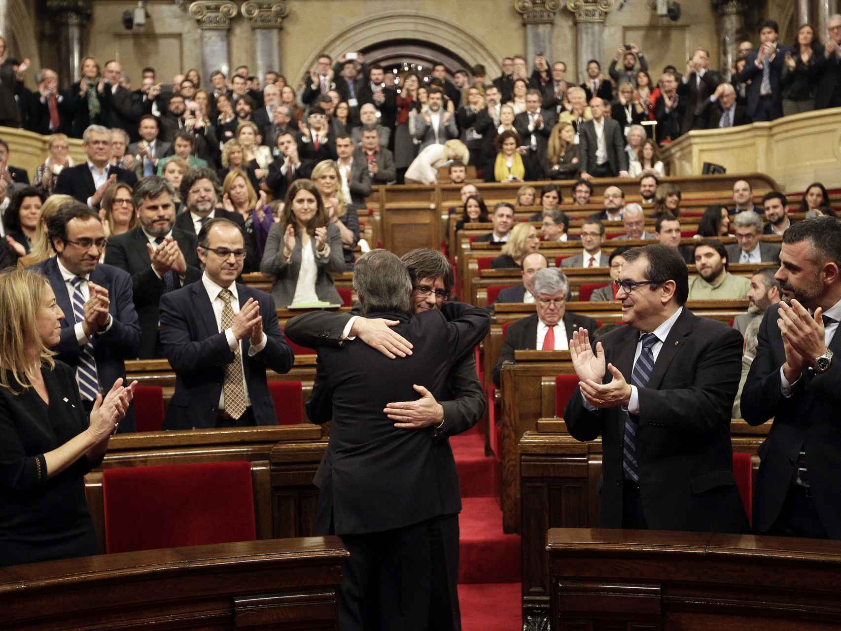 El Parlament aplaude el abrazo entre Mas y Puigdemont.