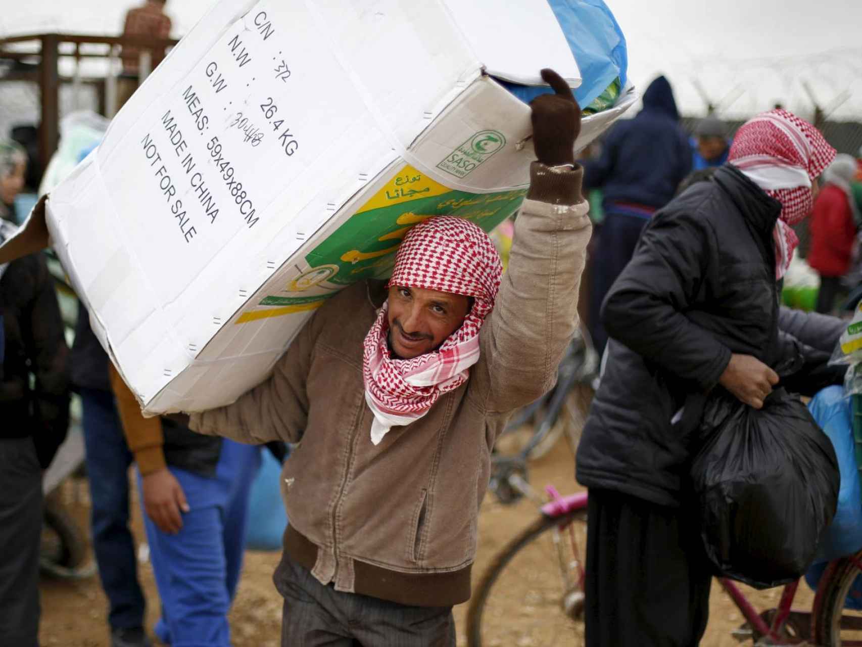 Refugiados sirios reciben ayuda en un campamento de Mafraq, Siria.