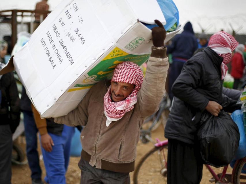 Refugiados sirios reciben ayuda en un campamento de Mafraq, Siria.