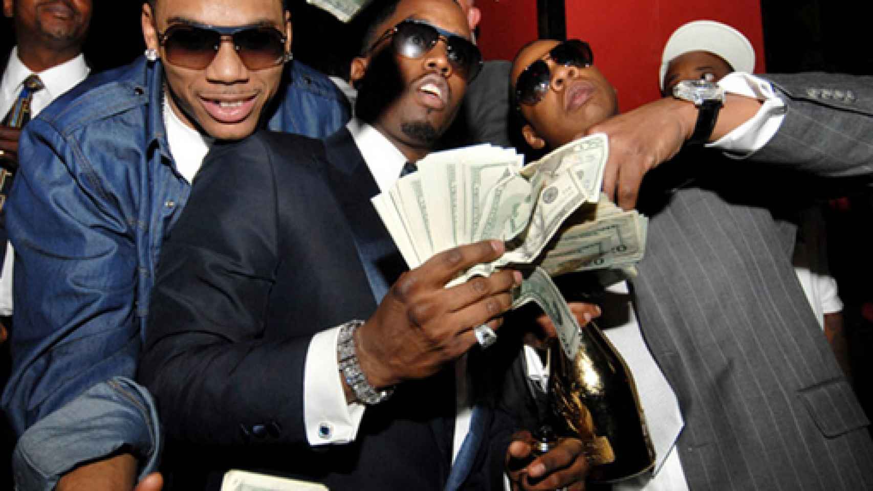 Puff Diddy y Jay Z tirando billetes mientras beben chapagne