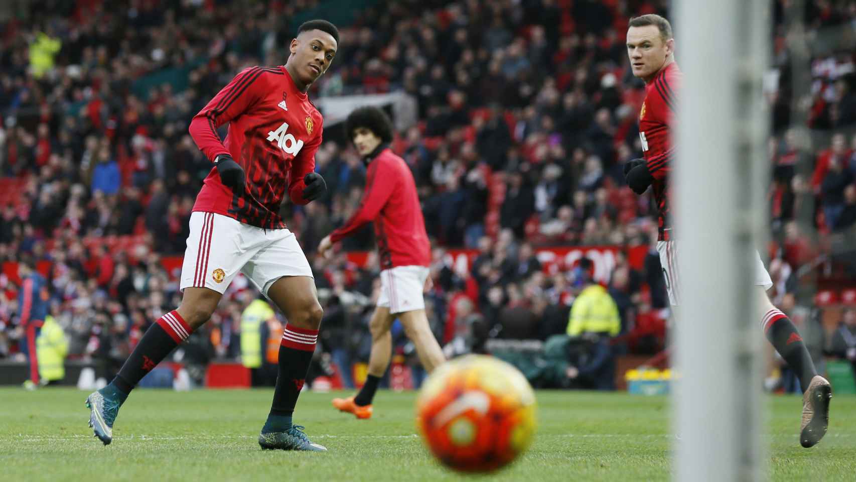 Martial y Rooney calientan antes de un encuentro del Manchester United.