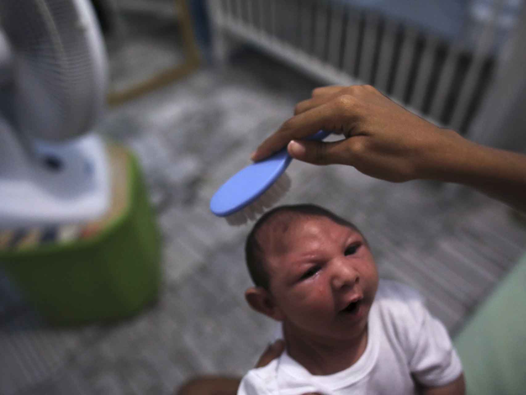 Daniele Santos peina a su hijo con microcefalia.