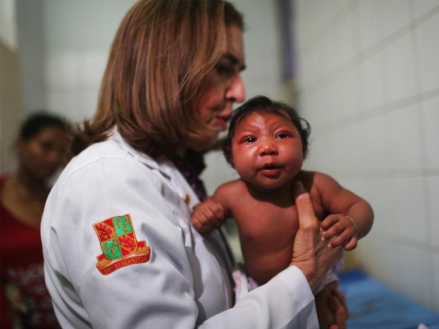 Una infectóloga con un niño afectado, en Recife (Brasil).