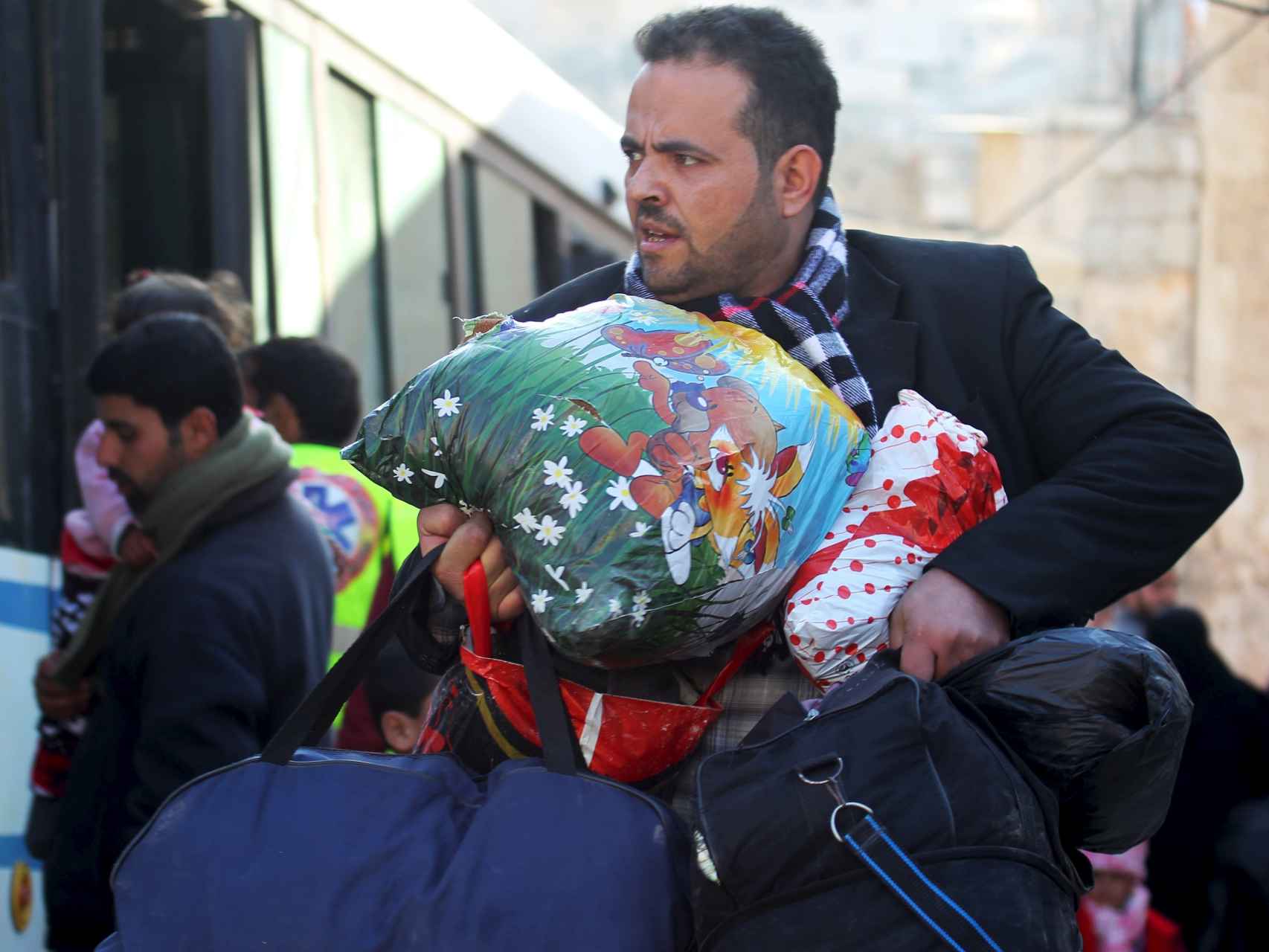 Los ciudadanos de Alepo huyen con la ayuda de autobuses.