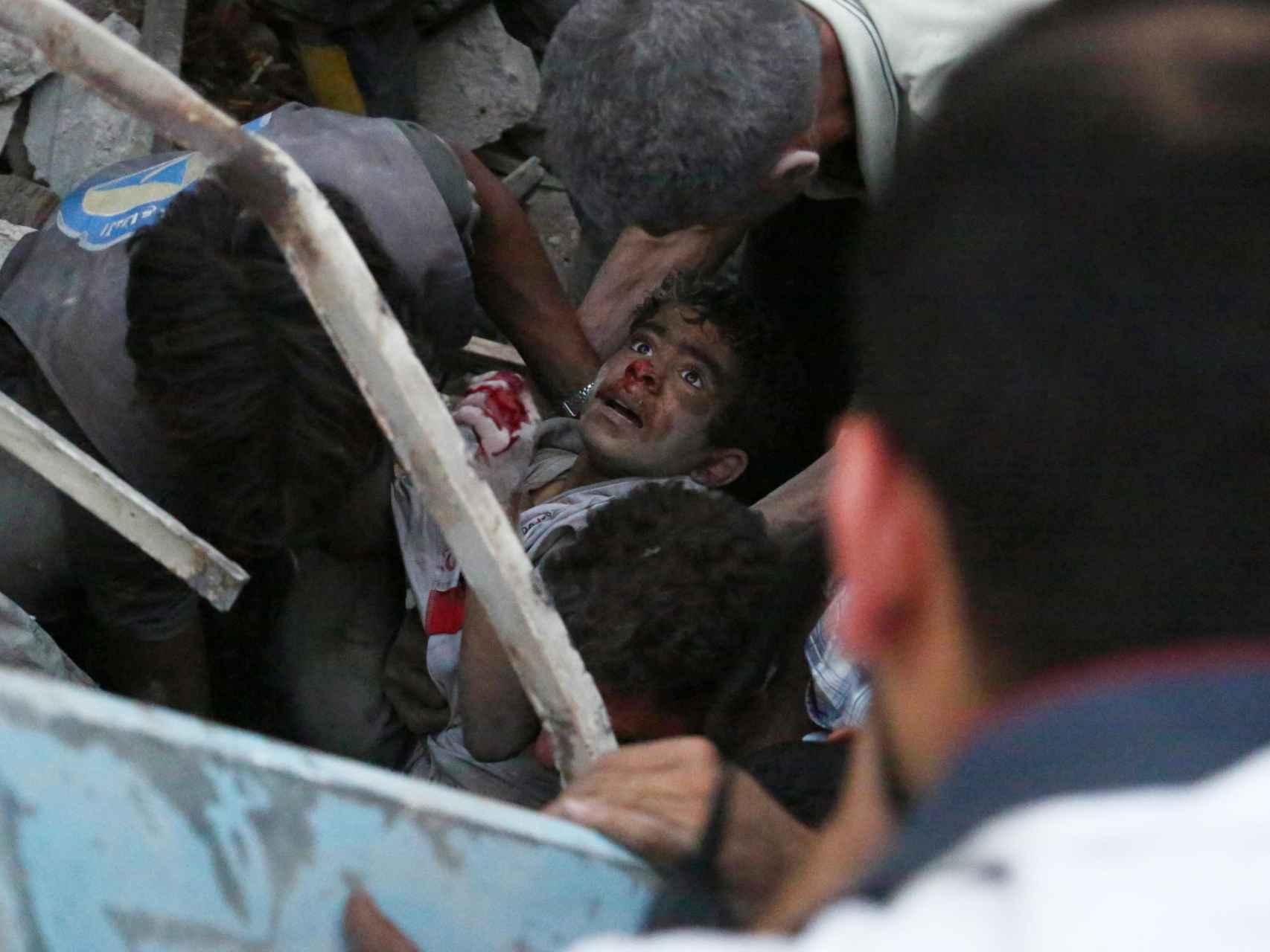 Un joven yace entre los escombros tras un bombardeo en Douma, Siria.