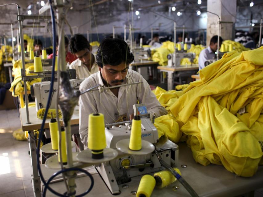 Trabajadores cosen camisetas fabricadas para Inditex en una fábrica en Pakistán.