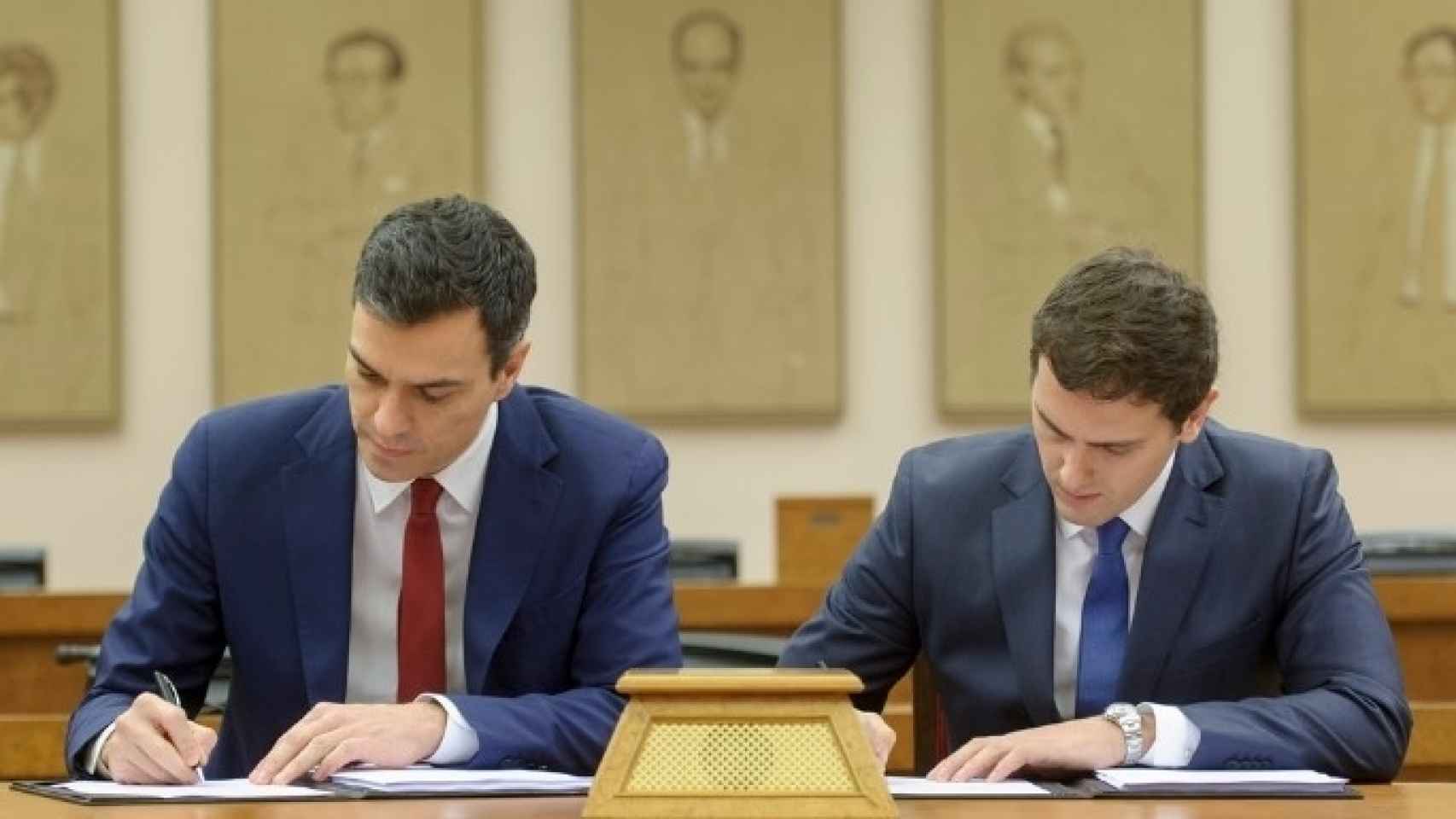 Sánchez y Rivera han inclinado la cabeza, apoyado la misma mano e utilizado el mismo bolígrafo durante la firma