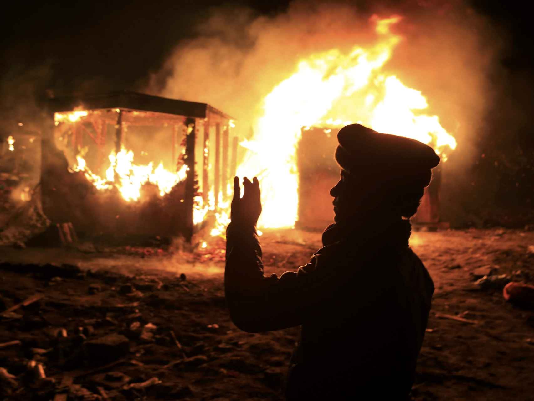 Un refugiado contempla cómo arde una de las cabañas